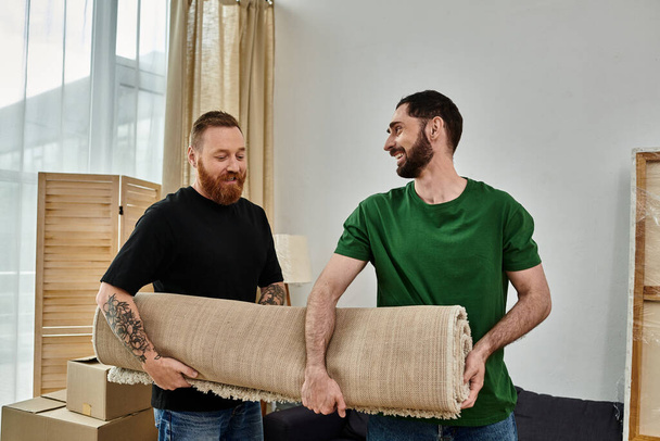 A gay couple in love, surrounded by moving carpet, standing together in their new home. - Photo, image
