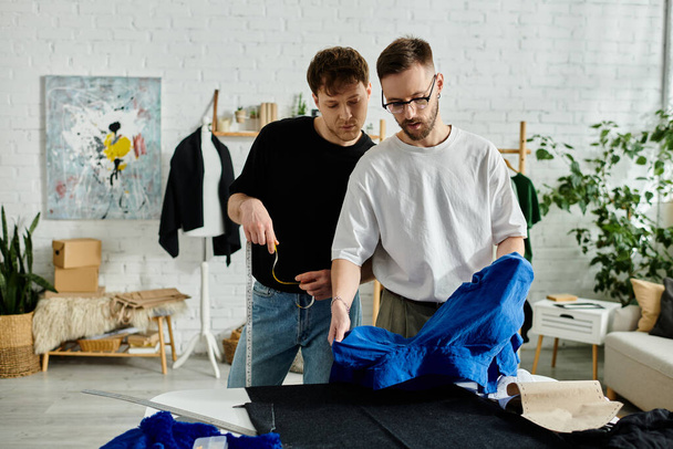 Two men in designer workshop, collaborating on trendy attire. - Photo, Image