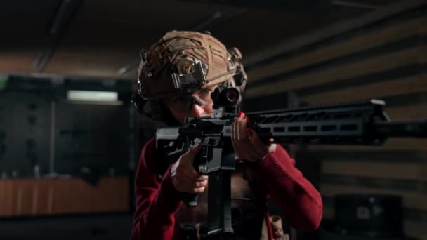 Egy profi lőtéren egy fiatal lány taktikai lőszerekkel készül lőni. - Felvétel, videó