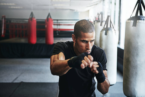 Kunto, lävistys ja mies nyrkkeilykehässä kuntosalille, haaste- tai kilpailukoulutukseen. Voima, lihas ja mestari nyrkkeilijä harjoituksissa luottamuksella, taistelulla ja energialla MMA-urheiluseurassa käsineillä - Valokuva, kuva
