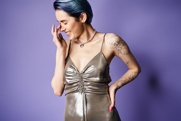 A young woman with blue hair strikes a pose in a stunning silver dress - Foto, Imagem
