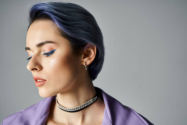 A young woman with blue hair styled in a trendy purple shirt poses confidently in a studio setting. - Photo, image