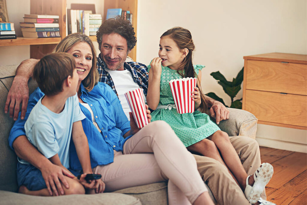 Щаслива сім'я, розслабитися і дивитися телевізор з попкорном для фільму, вихідних або свята на вітальні диван вдома. Мама, тато і діти з посмішкою і насолодою шоу, серіалу або потокового сервісу вдома. - Фото, зображення