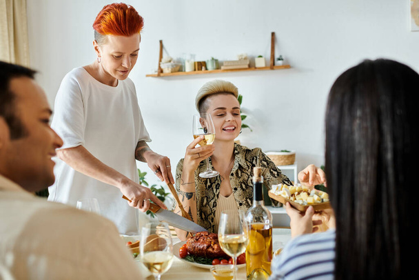 Diverse group enjoys meal together, lesbian couple hosts. - Foto, afbeelding