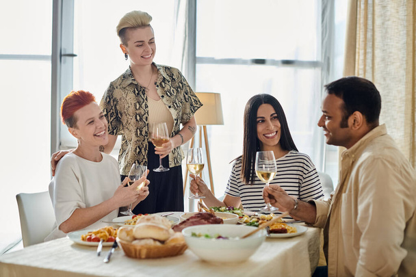 Diverso grupo disfruta del vino alrededor de una mesa. - Foto, imagen