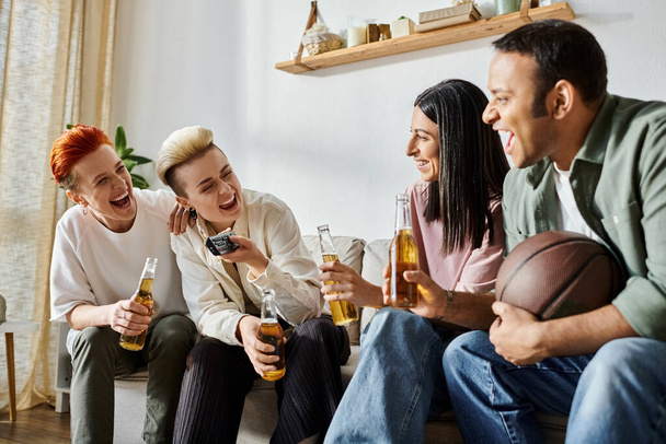 Diverse group holding beers on a couch. - Фото, зображення