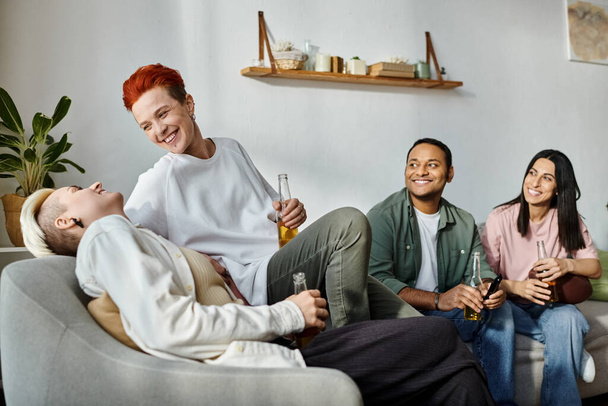 Diverse friends, including a loving lesbian couple, sit together on top of a comfy couch. - Photo, Image