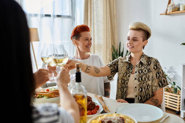 Monipuolinen ryhmä naisia istuu pöydän ympärillä, pitäen viinilaseja, ystävien kanssa.. - Valokuva, kuva