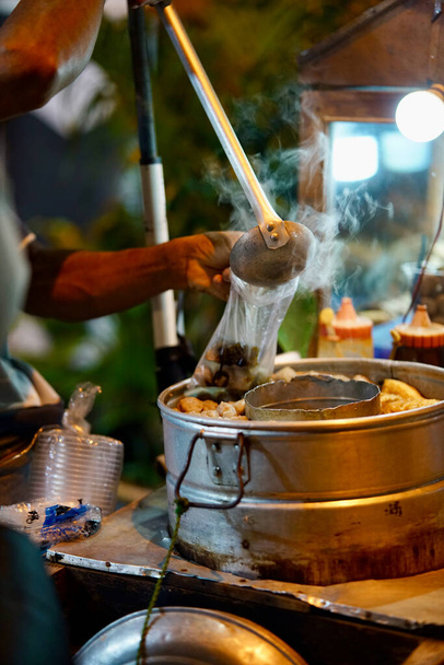 Tradycyjni indonezyjscy sprzedawcy meatball street przygotowujący zamówienia dla klienta w nocy - Zdjęcie, obraz
