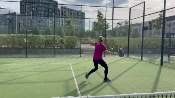  Fiatal sportos nő padel teniszezik lassított felvételen. Lassan üti a padel labdát a padel pályán. Kiváló minőségű 4k felvételek - Felvétel, videó