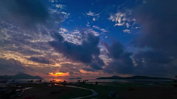 Zeitraffer schöner Himmel bei Sonnenaufgang über Fischerbooten. Sonnenaufgang über dem Rawai-Meer in goldenen bewölkten Tag.Fischerboote, die am Strand im Sonnenaufgang schwimmen. - Filmmaterial, Video