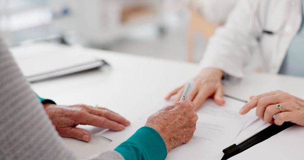 Hands, signature and doctor with patient and paperwork for healthcare and insurance. Talking, hospital and a medical employee with documents or a contract for a person while consulting for cardiology. - Foto, afbeelding