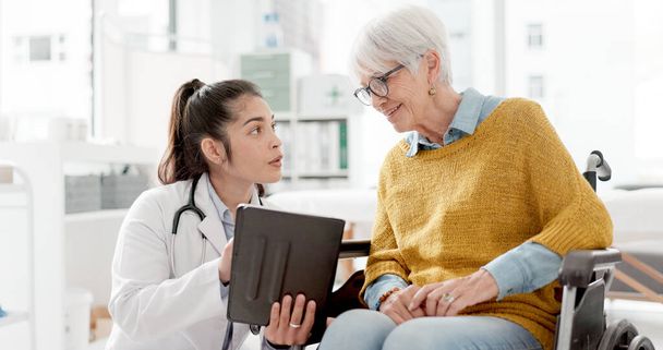 Tablet, results or doctor with old woman In wheelchair or consultation for healthcare in hospital clinic. Technology, appointment or medical worker talking to an elderly person with a disability. - Photo, Image