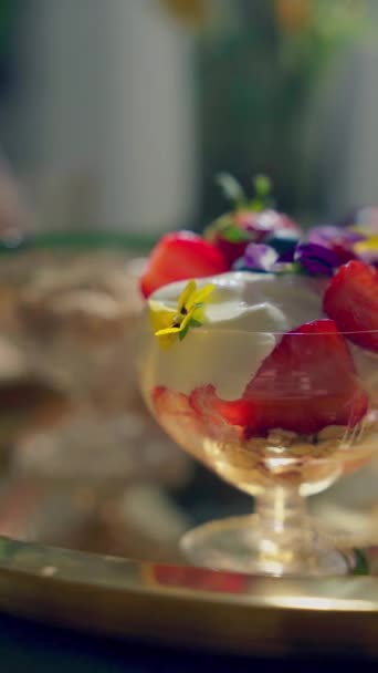 Крупним планом нічний вівса з ягодами і їстівними квітами подається в старовинних окулярах на золотому підносі. Дві порції. Концепція здорового сніданку. Вертикальне відео. Паннінг ліворуч. Високоякісні 4k кадри - Кадри, відео