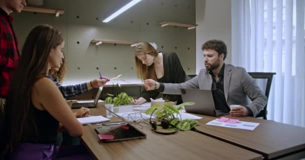 Jóvenes empresarios que se preparan y trabajan en un nuevo proyecto, analizando el papeleo y colaborando en un entorno de oficina moderno. - Metraje, vídeo