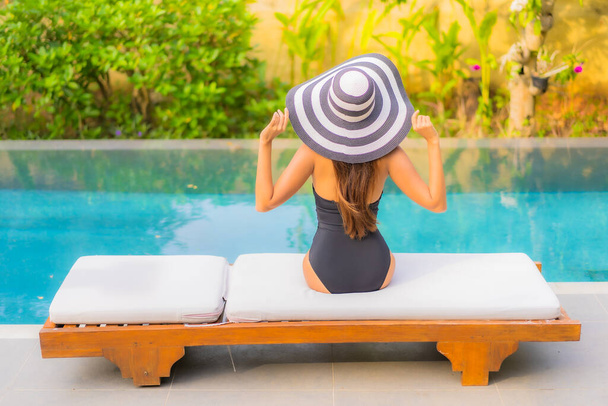 Retrato bonito jovem asiático mulher desfrutar relaxar ao redor piscina para lazer férias - Foto, Imagem