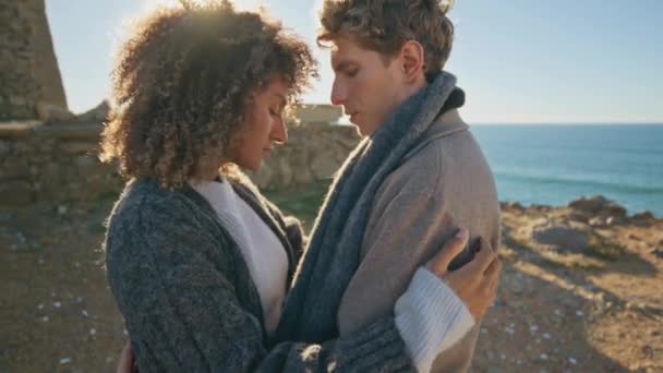 クローズアップ愛情のカップルは,海のビーチでカメラをポーズする互いに結合します. 女性を抱擁する美しい男. ロマンチックなデートを楽しむリラックスした少女 - 映像、動画