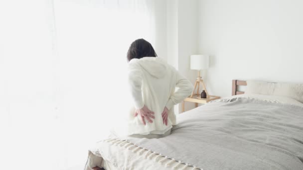 Eine Frau, die sich um ihren schmerzhaften unteren Rücken kümmert - Filmmaterial, Video