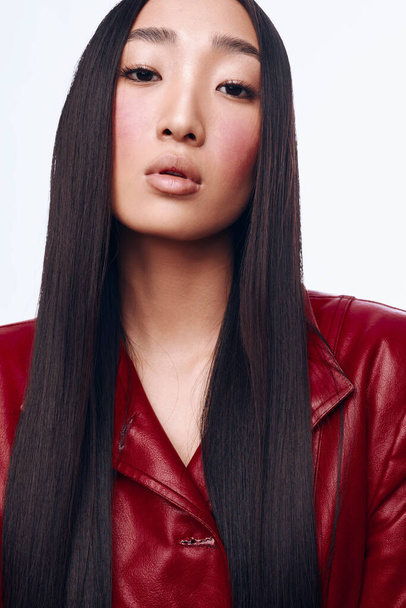 カメラのためのポジショニング赤い革のジャケットの長い黒い髪のスタイリッシュなアジアの女性 - 写真・画像
