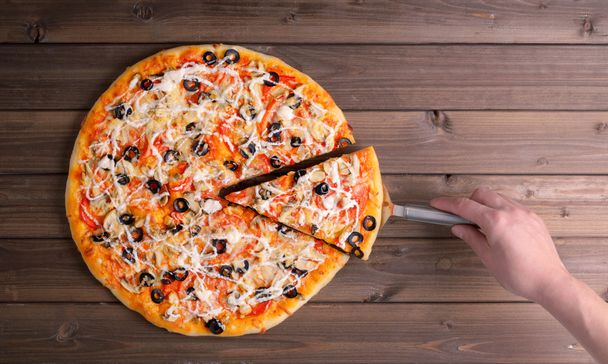 Pizza mit Käse und Pizzapaddel  - Foto, Bild