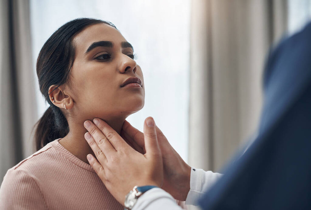 Nurse, woman and doctor with hand on throat, checking and thyroid issue or glands in healthcare appointment. Clinic, hospital exam and patient for wellness, infection and diagnosis with professional. - Foto, immagini