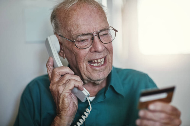 Senior man, telephone and yelling with credit card on call for banking, finance or issues on account at home. Elderly male person talking with debit in financial problem, retirement or pension fund. - Photo, Image