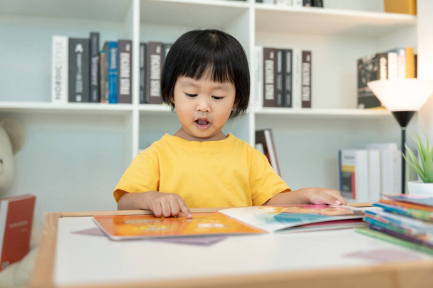 Счастливые азиатские дети расслабляются читать книги дома. дочь и чтение рассказа. научить развитию, уходу за детьми, смеху, образованию, рассказу историй, практике, представить, уменьшить зависимость мобильный телефон - Фото, изображение