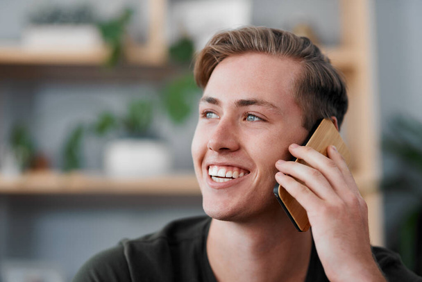 Happy man, phone call and conversation for communication, social media or networking in living room. Face, young male person and smile talking on mobile smartphone for online chatting or discussion. - Φωτογραφία, εικόνα