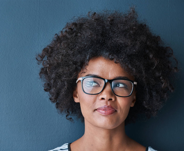 Black woman, thinking and frame or glasses with eyewear for eyesight, vision and confident. Blue background, female person and prescription for spectacles, lenses and service with ideas or vision. - Fotoğraf, Görsel