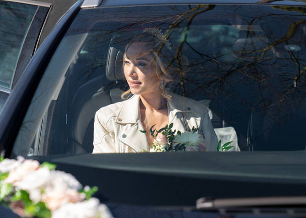 Wedding photo of the bride in the car through the glass - Photo, Image