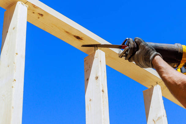 Работа с режущей пилой в строительной теме - энергетический инструмент для резки деревянных балок - Фото, изображение