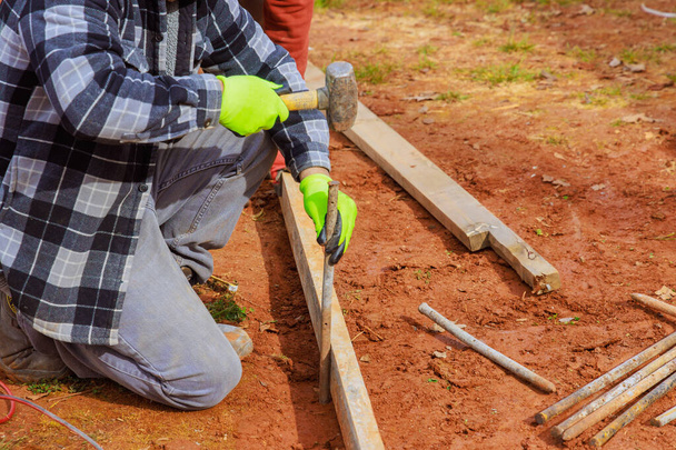 Les travailleurs de la construction produisent des gabarits avec coffrage en bois amovible pour couler le béton sur les fondations - Photo, image