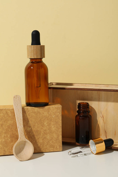 Aceite cosmético en una botella con una caja de madera - Foto, Imagen