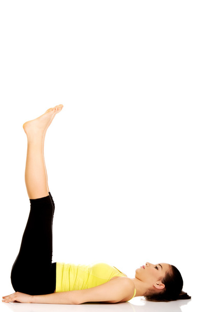 Fitness woman with her legs up. - Zdjęcie, obraz