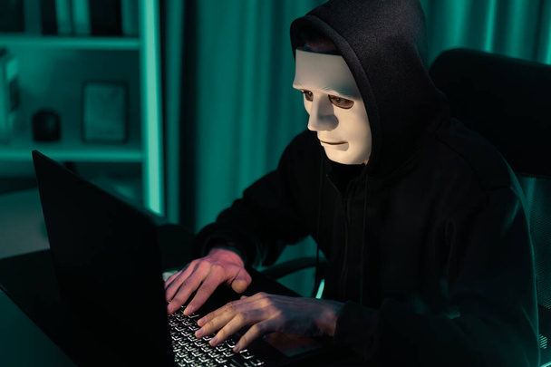 Біла кримінальна анонімна маска, що встановлює шифрування паролів за допомогою програмування зламування, намагаючись зробити безпечну конфіденційність, беручи масивну базу даних на комп'ютері для викупу компанії. Пекурі. - Фото, зображення