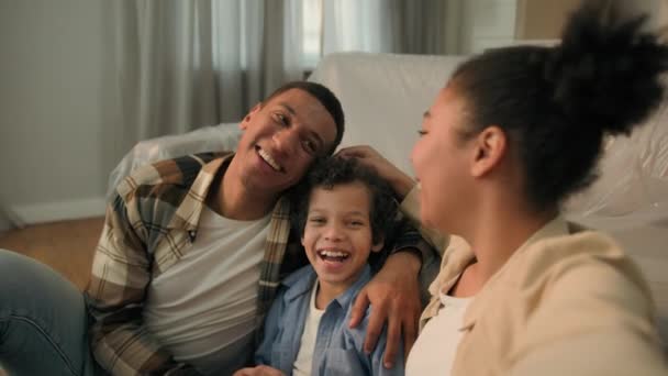 Glücklich afroamerikanische Familie sprechen Videoanruf Handy lustig fröhlich Eltern kleiner Sohn Junge Kind Lächeln aufnehmen Live-Blog Smartphone-Kamera am neuen Zuhause bewegenden Tag feiern Mama Papa Kind Selfie Foto - Filmmaterial, Video