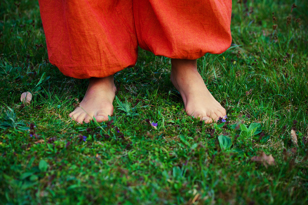 woman feet on the grass with orange pants - Photo, Image