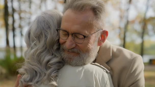 Eläkkeellä vanhempi kypsä vanha valkoihoinen mies syleilee halaileva halaus nainen kiintymys rakkaus pari puistossa ulkona mies nainen hellä liimaus tarjouksen halaus syleillä aviomies romanttinen tavata vaimo kaupungissa - Materiaali, video