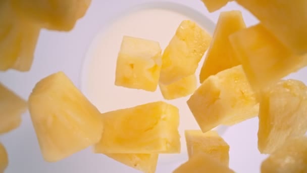 Super-Zeitlupenaufnahme von Ananasschnitten, gefolgt von einer Kamera, die mit 1000fps in Milch fällt. Gefilmt mit High-Speed-Kinokamera, 4K. - Filmmaterial, Video