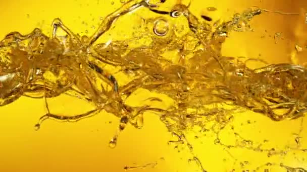 Super Slow Motion Shot of Oil Splashes Lecące w kierunku złotego tła z prędkością 1000fps. Nagrywane szybką kamerą filmową, 4k. - Materiał filmowy, wideo