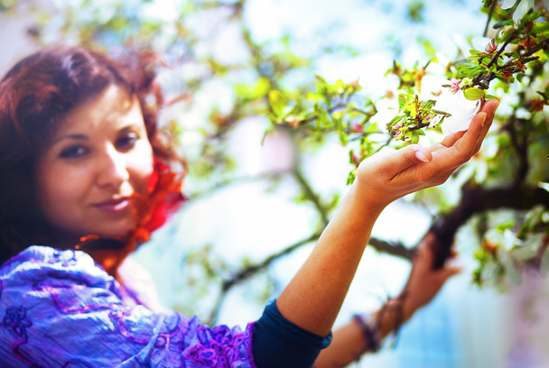 Giovane donna poetica con albero di magnolia in primavera. Donna che tiene il fiore
 - Foto, immagini