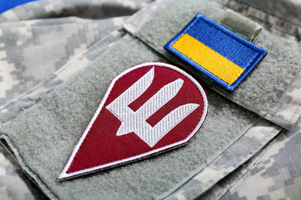 Vojenská uniforma s odznakem ukrajinské armády a vlajkou Ukrajiny, detailní záběr - Fotografie, Obrázek