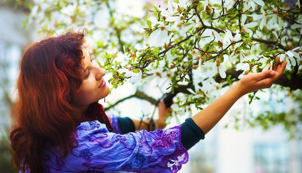 Mladá žena poetické magnolie strom v jarním období. Žena hospodářství květ - Fotografie, Obrázek