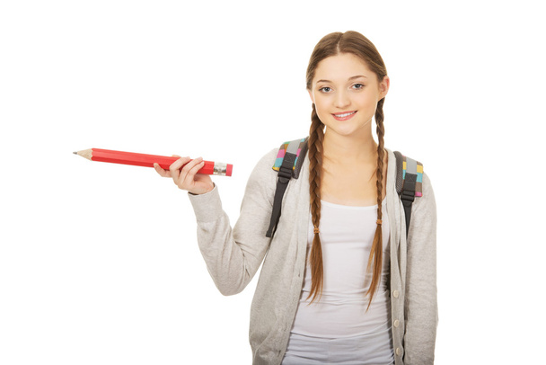 Schoolgirl pointing aside with pencil. - Φωτογραφία, εικόνα