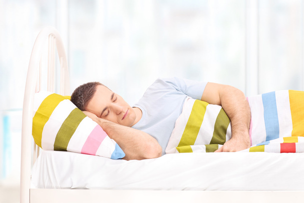 Man sleeping in a comfortable bed - Fotó, kép