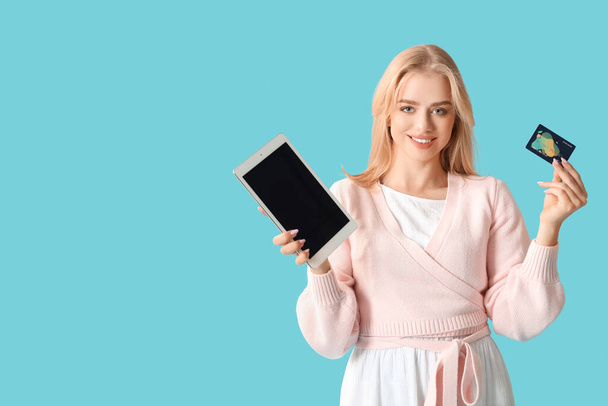 Νεαρή γυναίκα με σύγχρονο υπολογιστή tablet και πιστωτική κάρτα στο φόντο χρώμα - Φωτογραφία, εικόνα