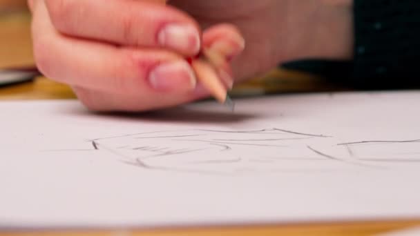 κοντινό πλάνο σε ένα εργαστήριο ραπτικής ένα γυναικείο χέρι σχεδιάζει ένα σκίτσο των μελλοντικών ρούχα - Πλάνα, βίντεο