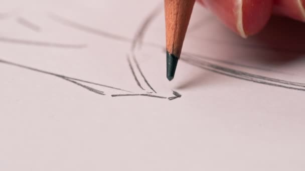 super close-up in een naaiatelier een vrouwenhand tekent een schets van toekomstige kleding - Video