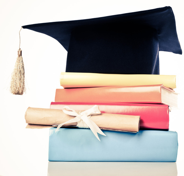 A mortarboard and graduation scroll on books - Foto, Imagem