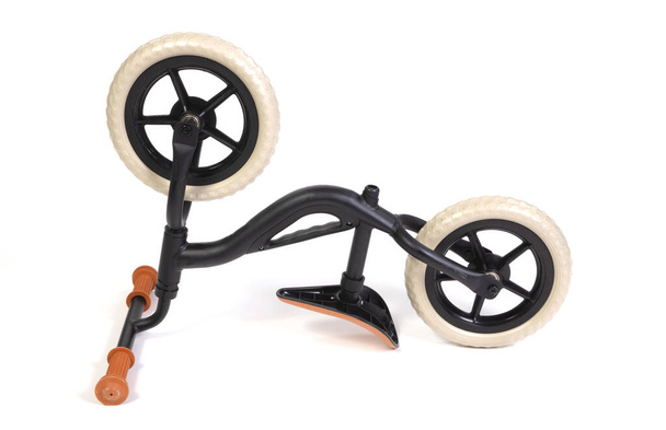 Μεταχειρισμένο μοντέρνο μαύρο balace ποδήλατο για ένα μικρό παιδί, απομονωμένο σε λευκό - Φωτογραφία, εικόνα
